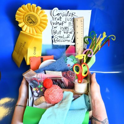Upcycle craft box filled with materials like string, scissors, pipe-cleaners, 3rd place ribbon